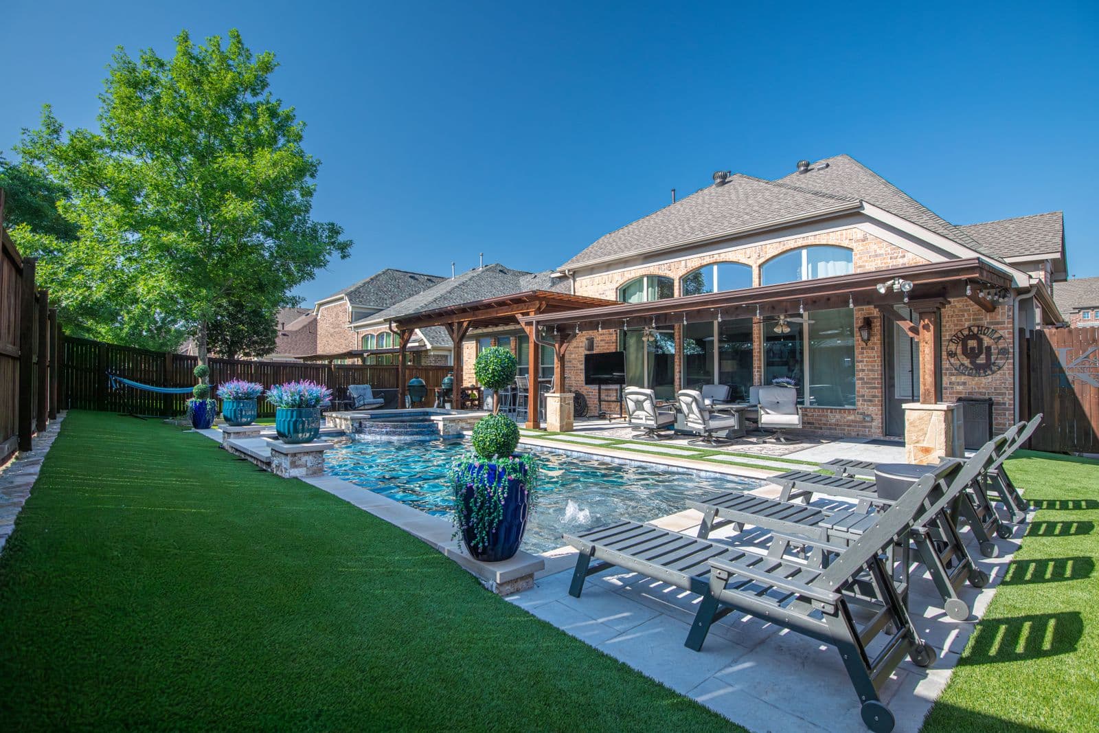 Manicured backyard with pergola, pool, and clipped lawn in Reno