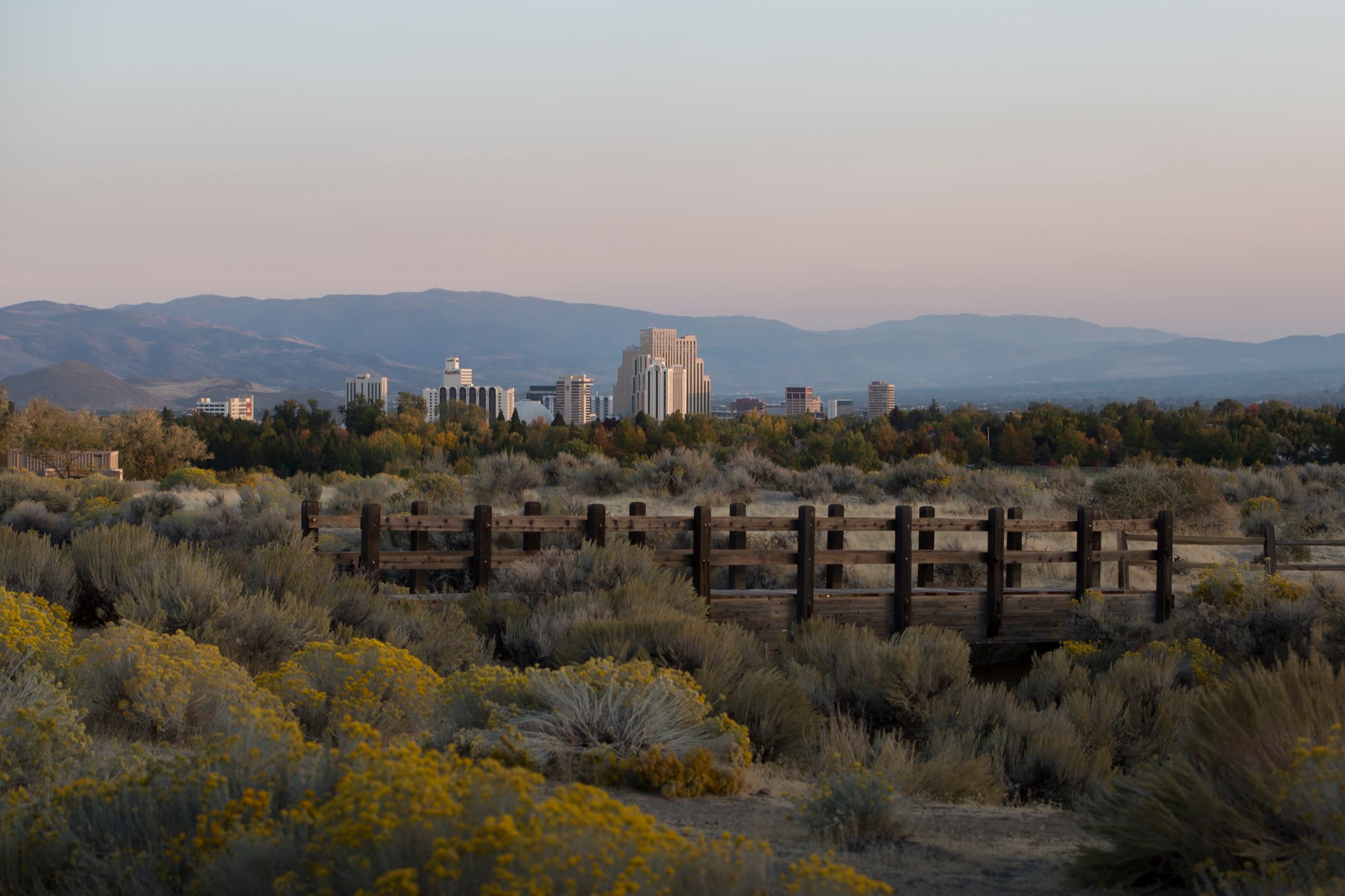 Scenic overview of Reno, Nevada — the downtown skyline with the high-desert foothills beyond at golden hour
